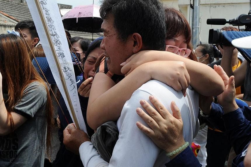 Relatives of the passengers on TransAsia Airways flight GE222 grieve for the victims at the crash site the day after the ATR 72-500 plane crashed near the airport at Magong on the Penghu island chain on July 24, 2014. &nbsp;-- PHOTO: AFP