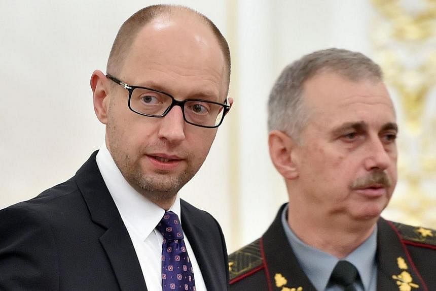 Ukrainian Prime Minister Arseniy Yatsenyuk (left) and Defence Minister Mykhaylo Koval arrive for a National Security and Defence Council sitting in Kiev on June 16, 2014. Mr&nbsp;Yatsenyuk on Thursday resigned in protest at the disbanding of the ruli