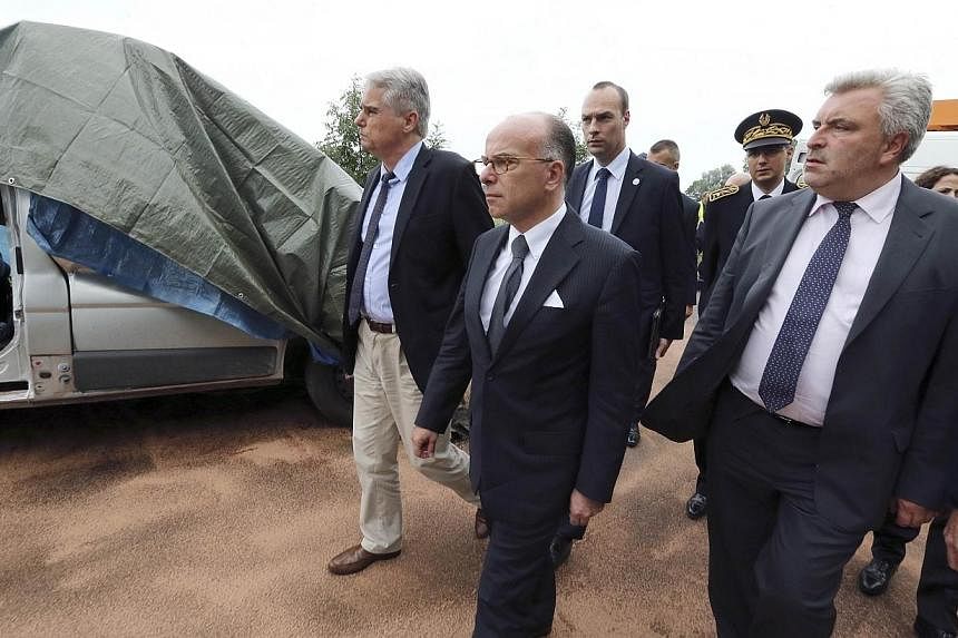 French Interior Minister Bernard Cazeneuve (centre) and French Transportation Minister Frederic Cuvillier (right) walk by the wreck of a minibus at the accident site after it crashed with a truck near Courteranges, outside Troyes, on July 22, 2014.&n