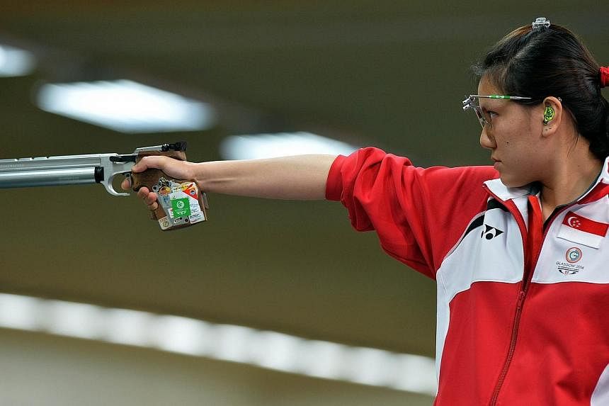 Teo Shun Xie of Singapore shoots during the 10m Air Pistol event at the Barry Buddon Shooting Centre in Carnoustie, Scotland on July 25, 2014, during the 2014 Commonwealth Games. -- PHOTO: AFP