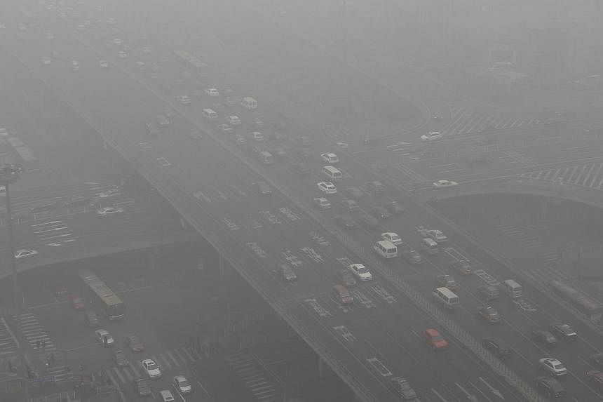 Vehicles drive through the Guomao Bridge on a heavy haze day in Beijing's central business district on Jan 29, 2013.&nbsp;China's overgrown and smog-hit capital has passed new rules banning the expansion of polluting and resource-intensive industries