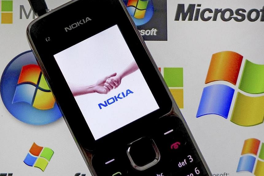 A Nokia mobile phone lies on a tablet computer showing logos of Microsoft, in this illustration photo taken in Frankfurt on Nov 18, 2013. -- PHOTO: REUTERS