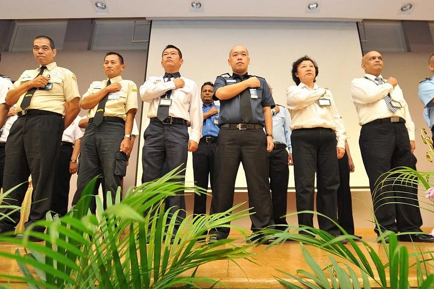 Security guards at the inaugural “security officers day” yesterday, pledging to help the police protect lives and properties. -- PHOTO: LIM YAOHUI FOR THE STRAITS TIMES
