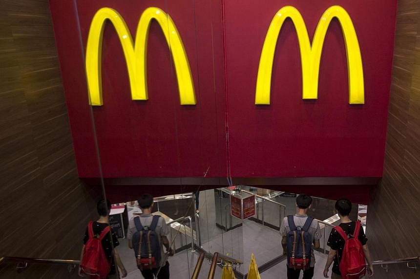 Customers walk into a McDonald's store in Hong Kong on July 25, 2014. McDonald's Hong Kong has suspended sales of chicken nuggets and several other items after admitting it imported food from a US-owned firm in China at the centre of an expired meat 