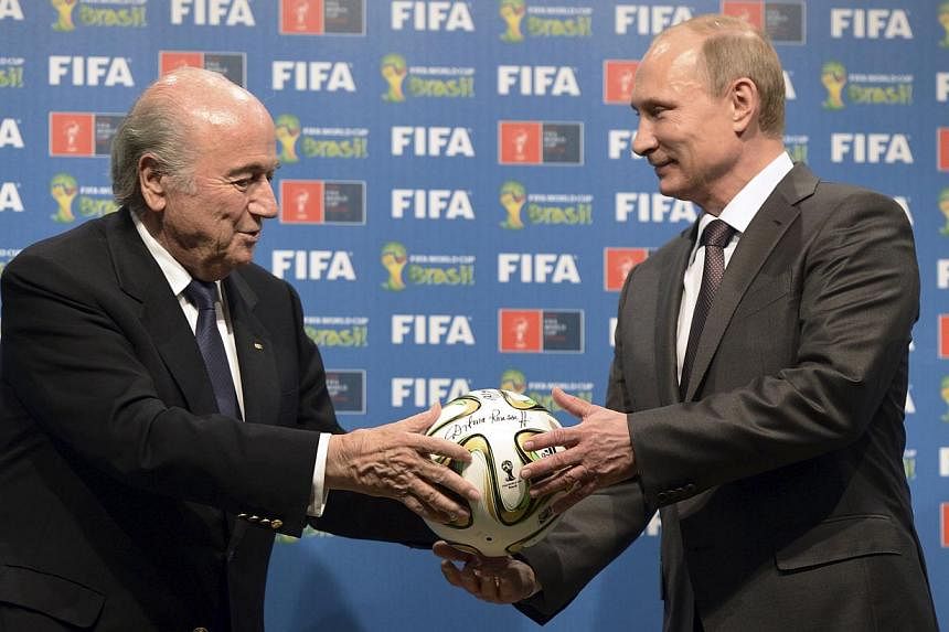 Russia's President Vladimir Putin (right) and Fifa president Sepp Blatter take part in the official handover ceremony for the 2018 World Cup scheduled to take place in Russia, in Rio de Janeiro on July 13, 2014.&nbsp;-- PHOTO: REUTERS
