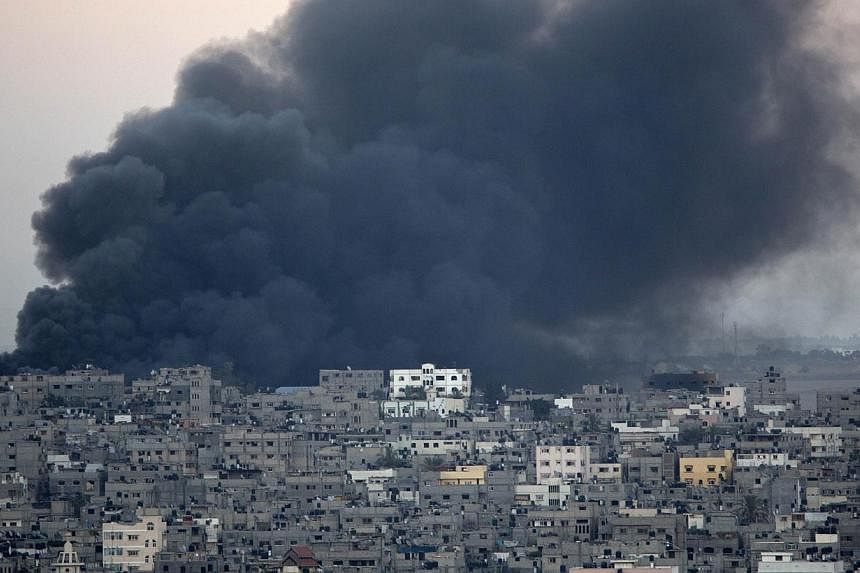 Smoke billows from a building hit by an Israeli air strike in Gaza City on July 25, 2014.&nbsp;The Israeli military and Hamas said on Saturday that they would observe a 12-hour ceasefire from 8:00 am (1:00pm Singapore time), but a longer-term truce r