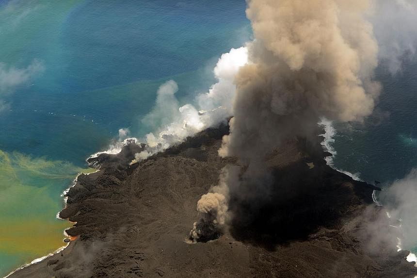 This handout picture taken by Japan Coast Guard on July 23, 2014 shows the newly created islet and Nishinoshima island, which are conjoined with erupting lava at the Ogasawara island chain, 1,000 kilometres south of Tokyo. A smouldering islet off Jap