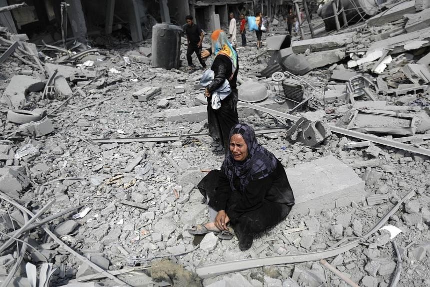 A Palestinian woman reacts at seeing destroyed homes in the northern district of Beit Hanun in the Gaza Strip during an humanitarian truce on July 26, 2014. -- PHOTO: AFP