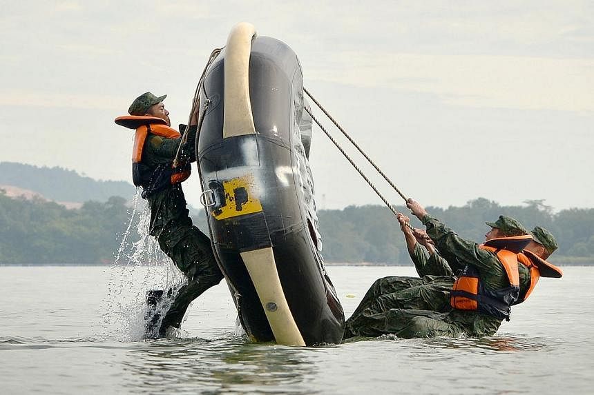 Capsize drills, where trainees learn how to flip an inflatable boat using their body weight, are performed in the sea just off the Sembawang Camp.&nbsp;-- ST PHOTO: ALPHONSUS CHERN