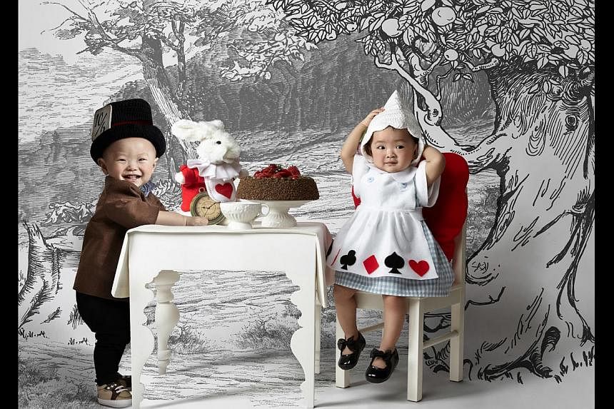 Ms Johanna Thean’s newborn daughter, Jodi Huang, dressed as Snow White and Ms Vanessa Ong’s twins, Gerick and Glenise Tan (both above) as the Mad Hatter and Alice from Alice In Wonderland when they were a year old. -- PHOTO: VIVIEN NG