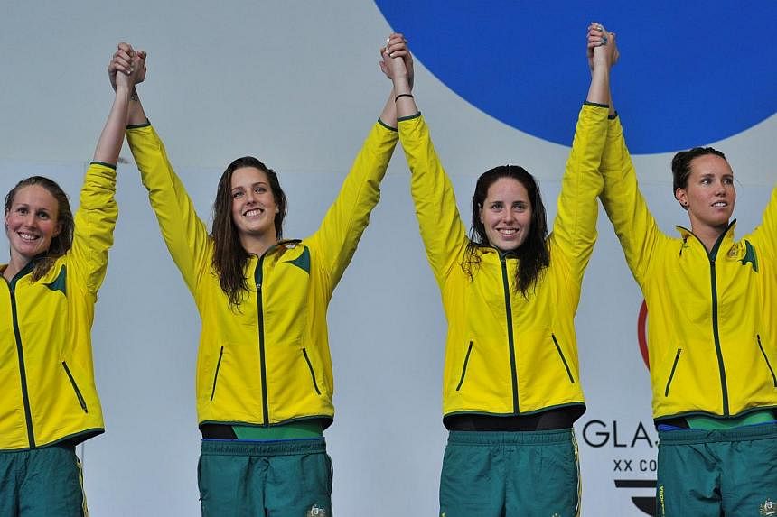 Gold medallists Australia's Emma McKeon, Australia's Alicia Coutts, Australia's Brittany Elmslie and Australia's Bronte Barratt pose on the podium during the Women's 4 x 200m Freestyle medal ceremony at the Tollcross International Swimming Centre dur