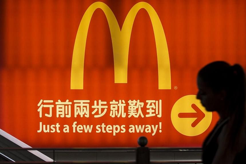 A woman walks past a logo of McDonald's in Hong Kong on July 25, 2014. -- PHOTO: REUTERS