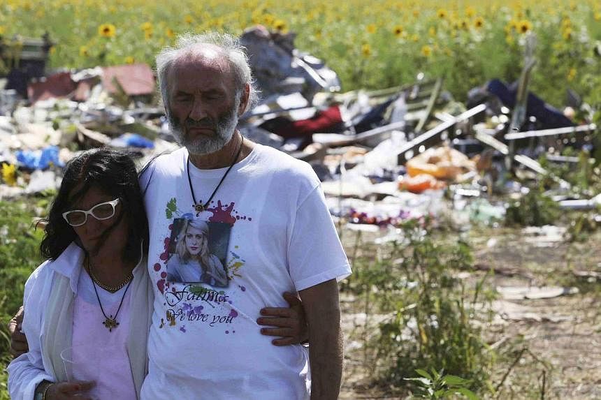 George and Angela Dyczynski walk near wreckage of the downed Malaysia Airlines Flight MH17, during their visit to the crash site near the village of Hrabove, Grabovo, in Donetsk region on July 26, 2014. -- PHOTO: REUTERS