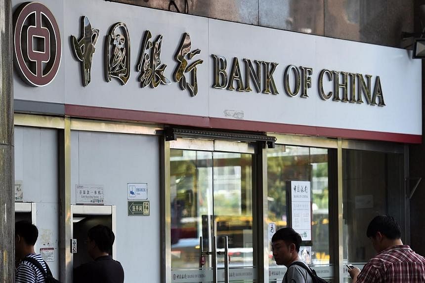 People waiting outside a Bank of China branch in Beijing on July 11, 2014. The Bank of China (BOC) has denied accusations by state television that it helped clients evade limits on money transfers overseas, in a rare attack by the government broadcas