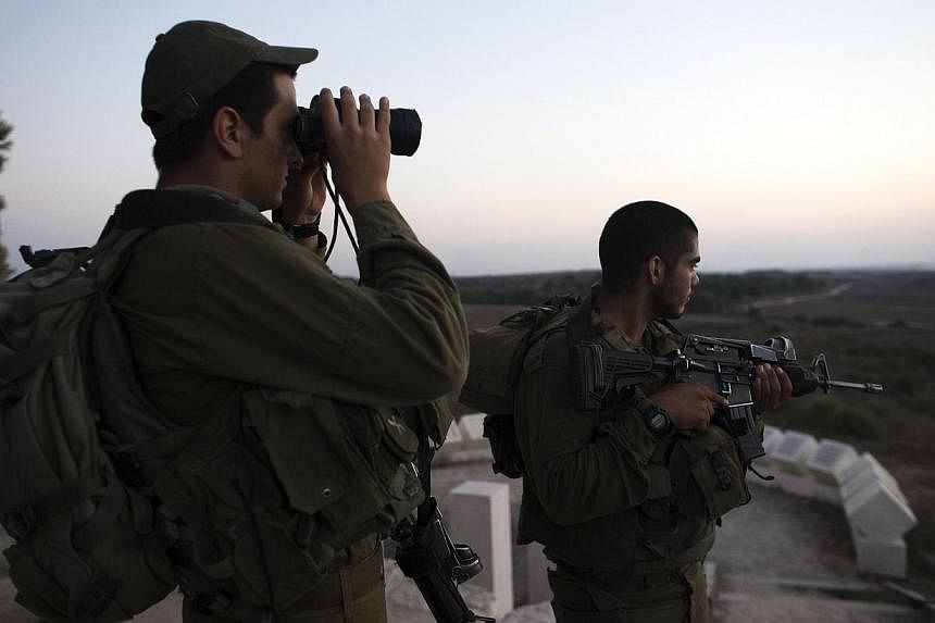 Israeli soldiers stand near the border with the Gaza Strip on July 26, 2014.&nbsp;The Israeli army said on Sunday, July 27, that it is resuming its raids on Gaza by land, sea and air after Hamas continued firing rockets, ending a unilateral 12-hour h