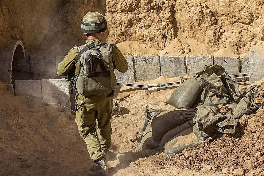 An Israeli army officer stands at the entrance of a tunnel said to be used by Palestinian militants for cross-border attacks, during an army organised tour for journalists on July 25, 2014.&nbsp;Egypt's army said Sunday, July 27 it has destroyed 13 m