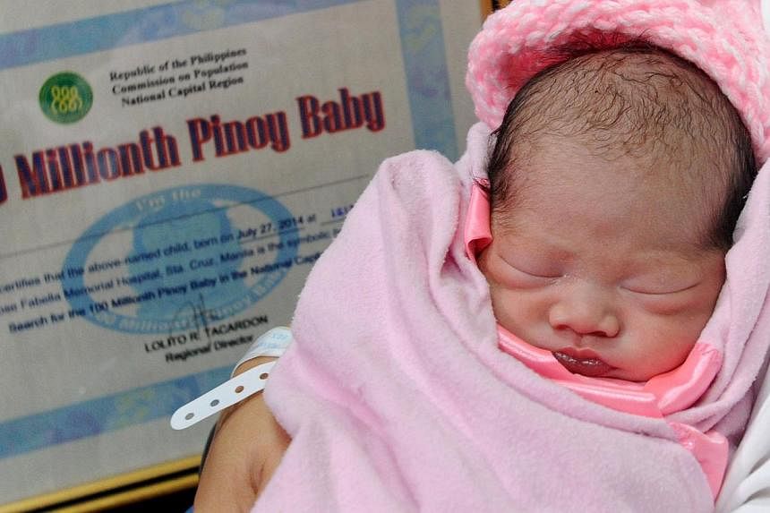 Newly-born baby girl Jennalyn Sentino, who has been designated as the Philippines' "100,000,000th baby", sleeps during a presentation at a government hospital in Manila on July 27, 2014. -- PHOTO: AFP