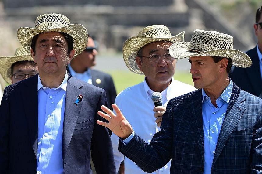 Japanese Prime minister Shinzo Abe (left) listens to Mexican President Enrique Pena Nieto (right) during a visit to Teotihuacan, Mexico State on July 26, 2014. -- PHOTO: AFP