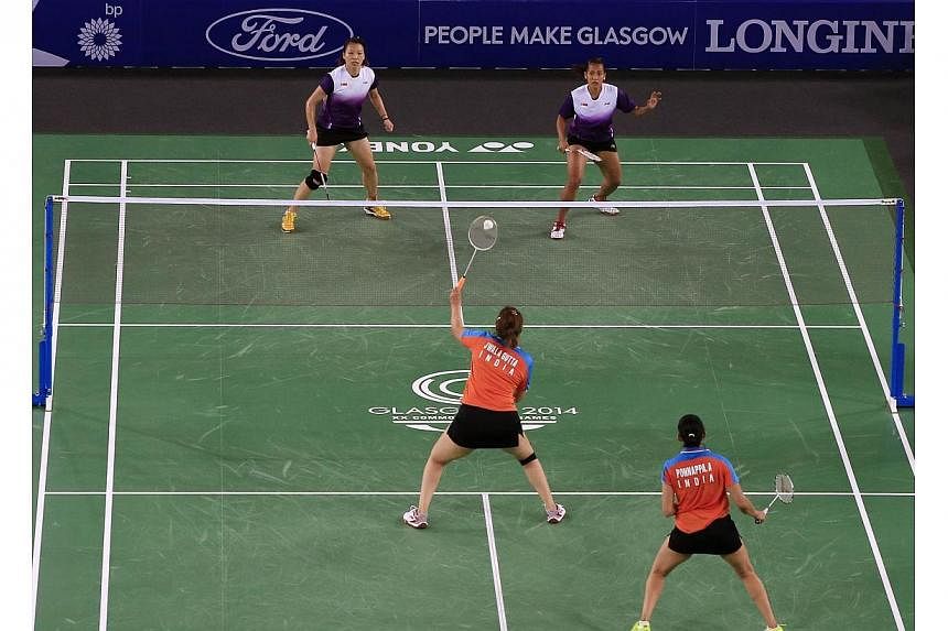 Singapore's Shinta Mulia Sari (top right) besides her doubles partner Lei Yao (top left) against India's Ashwini Ponnappa (bottom right) and Jwala Gutta (centre) in the Mixed Team event at the Emirates Arena at the 2014 Commonwealth Games in Glasgow 