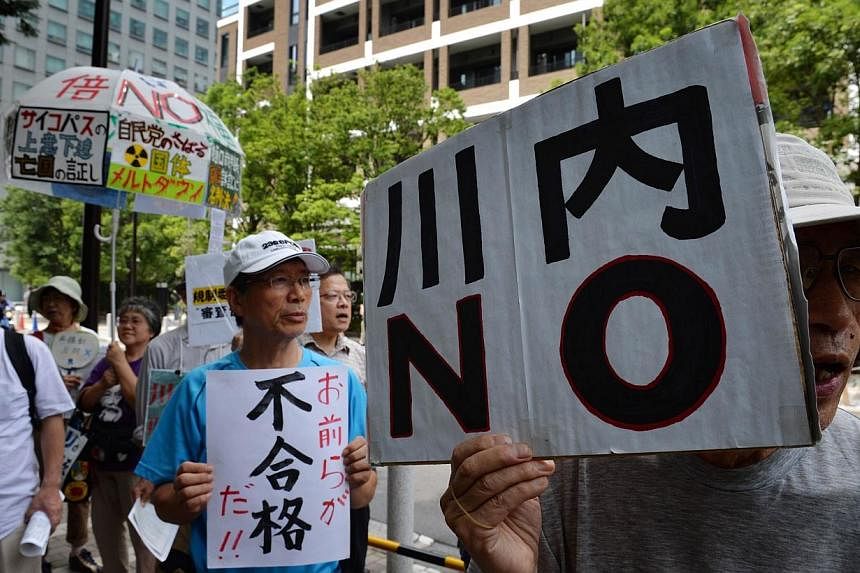 An anti-nuclear protester holds a placard reading "Sendai NO", in reference to the Sendai Nuclear Power Plant in Kyushu, during a rally in Tokyo on July 16, 2014.&nbsp;Japanese officials are handing out radiation-blocking iodine tablets to people liv
