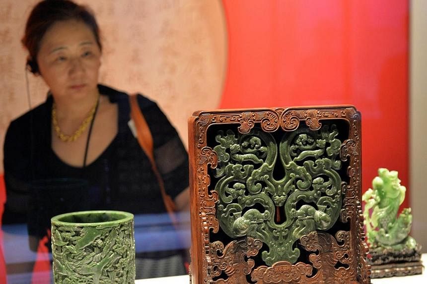A woman looks at artefacts and artworks displayed at Japan's national museum during a preview of the 'Treasured Masterpieces from the national Palace Museum, Taiwan' in Tokyo on June 23, 2014.&nbsp;Taiwan's first lady will resume a rare visit to Japa