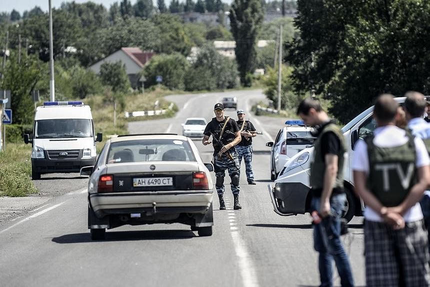 Pro-Russian militants block the way behind Dutch and Australian forensic teams on their way to the crash site of the Malaysia Airlines flight MH17 on Monday, July 28, 2014 in Donetsk.&nbsp;Dutch and Australian forensic investigators on their way to t