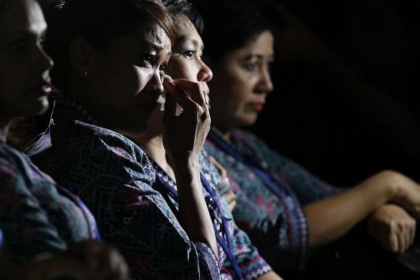 Malaysia Airlines flight attendants cry during a multi-faith event to pray for the passengers and crew of MH17 at the airline's academy in Kuala Lumpur, on July 25, 2014. -- PHOTO: REUTERS
