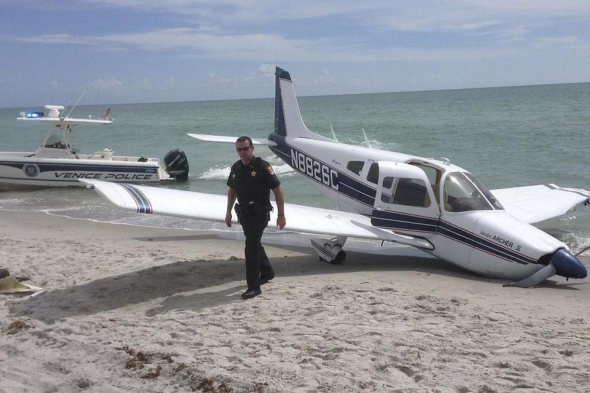 First responders respond at the scene of a single engine Piper Cherokee plane crash in this photo provided by the Sarasota County Sheriff's Office in Caspersen Beach in Venice, Florida on July 27, 2014.&nbsp;A small plane crash-landed on a beach in t