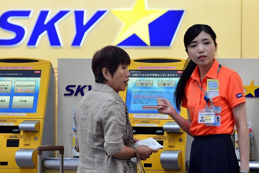 A ground staff (right) of Japan's Skymark Airlines guides a customer at the self check-in counter of Skymark Airlines at Haneda airport in Tokyo on July 29, 2014.&nbsp;Airbus on Tuesday said it has cancelled a US$2.2 billion (S$ 2.7 billion) deal wit