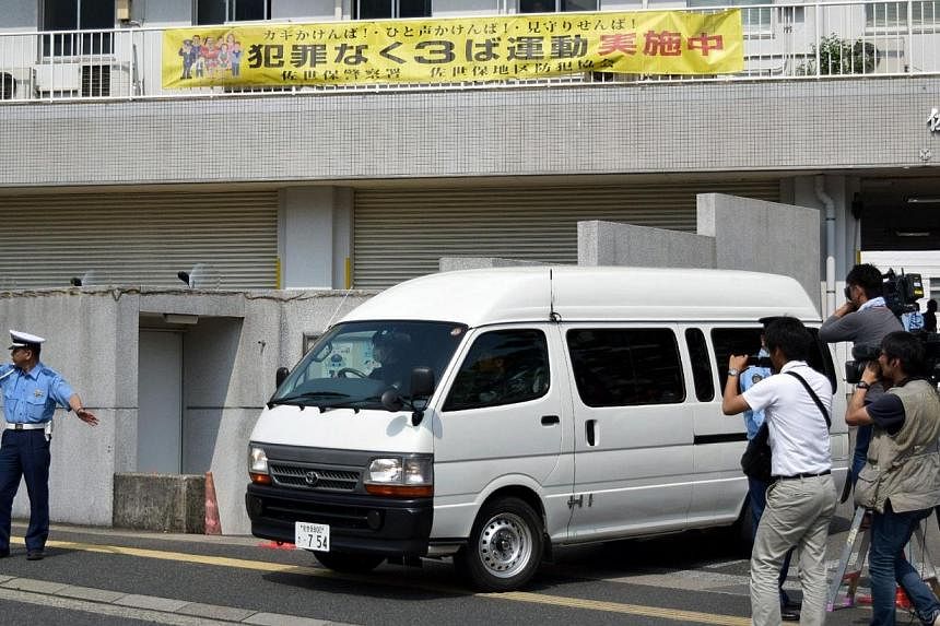 A van carrying a 15-year-old high schoolgirl, who was arrested on suspicion of killing a school friend at her home, leaves a police station for the prosecutor's office in Sasebo in Nagasaki prefecture, on Japan's southern island of Kyushu on July 28,