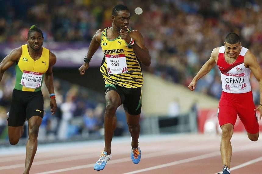 Kemar Bailey-Cole (centre) of Jamaica finishes first place ahead of Adam Gemili (right) of England, and Jason Livermore of Jamaica during the men's 100m final at the 2014 Commonwealth Games in Glasgow, Scotland, on July 28, 2014.&nbsp;Kemar Bailey-Co