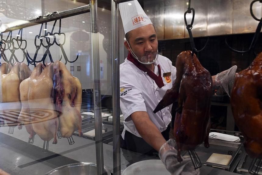 This photo taken on July 24, 2014 shows a chef preparing Peking Duck at the Quanjude restaurant in Beijing. -- PHOTO: AFP
