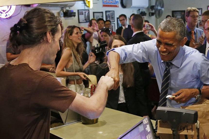 U.S. President Barack Obama fist bumps the cashier after paying for his order at Franklin Barbecue in Austin, Texas. -- PHOTO: REUTERS&nbsp;