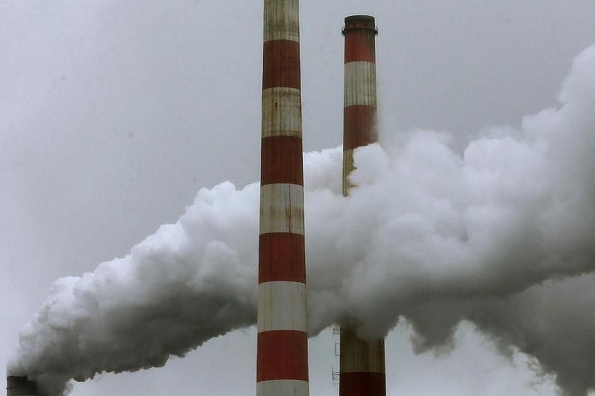 Emissions spew out of a large stack at the coal fired Morgantown Generating Station, on May 29, 2014 in Newburg, Maryland.&nbsp;Delaying efforts to reduce greenhouse gas emissions could cost the US $150 billion (S$190 billion) per year, the White Hou