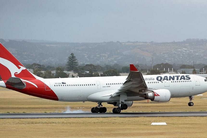 This picture taken on Dec 10, 2013 shows a Qantas flight landing at the Adelaide airport in Adelaide.&nbsp;Australian airline Qantas said on Tuesday it would continue flying over Iraqi airspace, despite alliance partner Emirates deciding to alter its