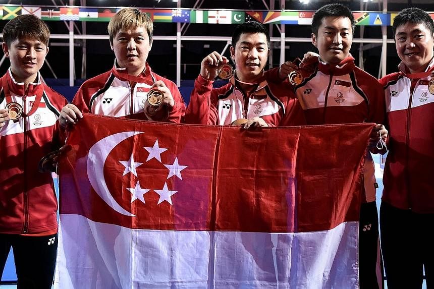 Singapore's players pose with their national flag after winning the gold medal in the table tennis team final at the Scotstoun Sports Campus at the 2014 Commonwealth Games in Glasgow on July 28, 2014.&nbsp;Singapore have won gold in the Commonwealth 