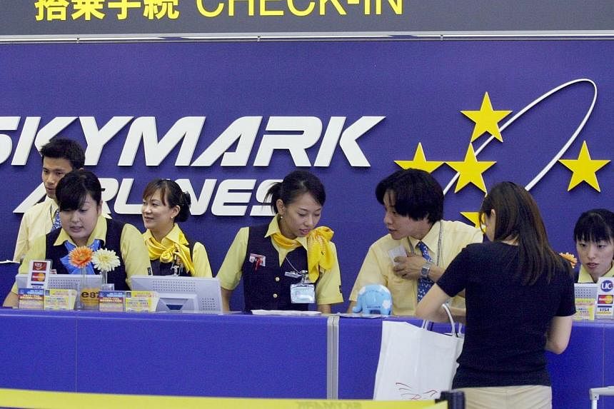 A passenger buys tickets at a Skymark Airlines Co. check-in counter at Haneda Airport in Tokyo Wednesday, July 14, 2004.&nbsp;European planemaker Airbus is set to lose its only Japanese customer for the A380 superjumbo as Skymark Airlines prepares to