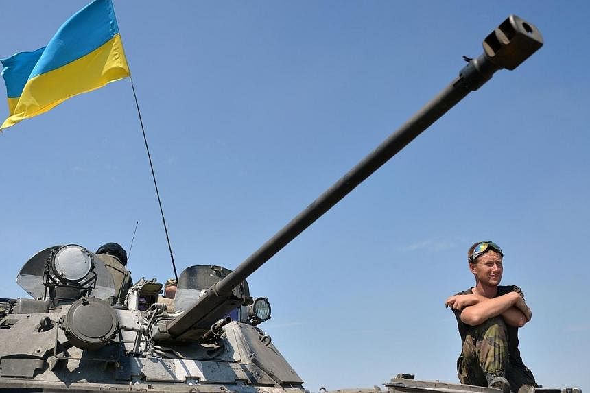 A Ukrainian service man looks out from a tank flying the Ukrainian flag,, part of a convoy of vehicles of the Ukrainian forces driving towards the eastern Ukrainian city of Lysychansk, in the region of Lugansk, on July 25, 2014.&nbsp;Senior American 