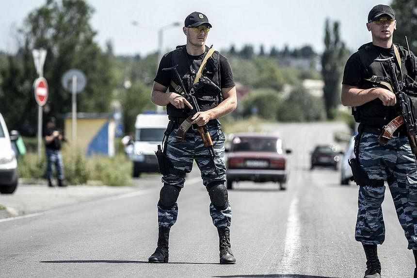Pro-Russian militants block the road to the crash site of the Malaysia Airlines flight MH17 on July 28, 2014 in Donetsk.&nbsp;Ukraine's army said on Wednesday, July 30, 2014, that it had retaken a town on the outskirts of the main rebel stronghold of