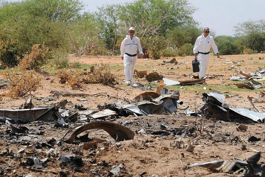 Investigators gather evidence at the crash site of the Air Algerie AH5017 in Mali's Gossi region on July 29, 2014.&nbsp;&nbsp;Dressed in protective white overalls, French experts sift through the debris of the Air Algerie plane that disintegrated ove