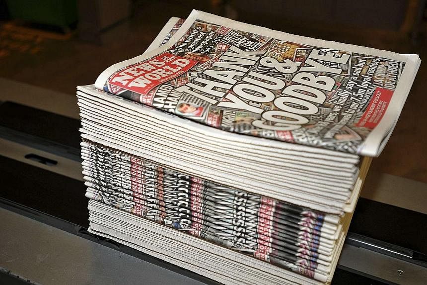 Copies of the final edition of the News of the World roll are seen at the News International print works in Waltham Cross, southern England on July 9, 2011.&nbsp;Two more senior journalists from Rupert Murdoch's defunct British tabloid the News of th