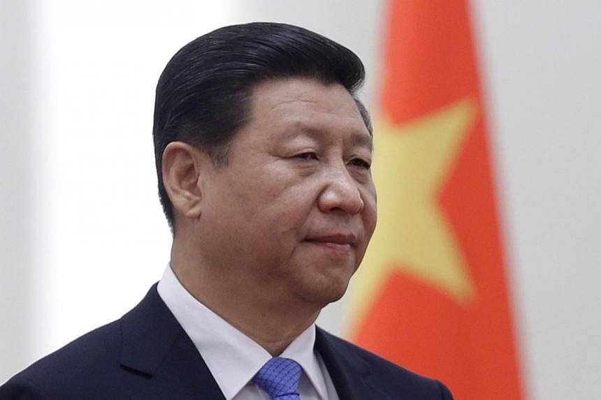 China's President Xi Jinping stands next to a Chinese national flag during a welcoming ceremony at the Great Hall of the People, in Beijing on Nov 13, 2013. Mr Xi is emerging as the country's most powerful leader in decades, analysts said, after the 