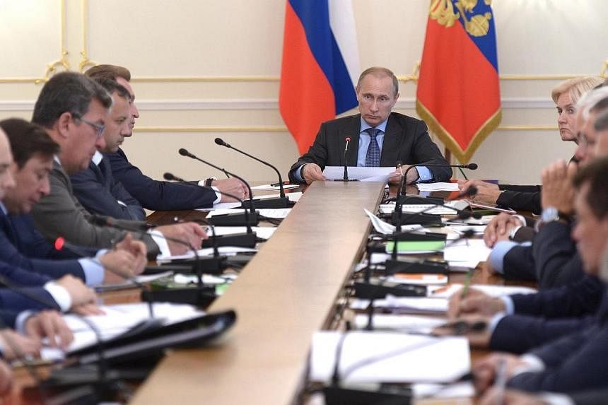 Russia's President Vladimir Putin (centre) chairs a government meeting at the Novo-Ogaryovo state residence outside Moscow on July 30, 2014.&nbsp;Russia fought back on Wednesday, July 30, 2014, over new United States and European Union sanctions impo