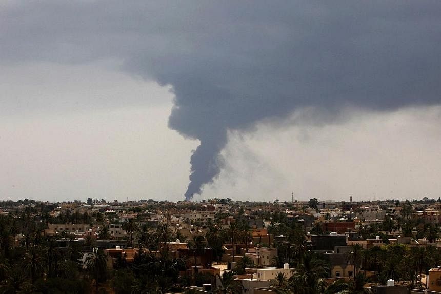 Plumes of smoke rise in the sky after a rocket hit a fuel storage tank near the airport road in Tripoli, during clashes between rival militias on July 28, 2014. -- PHOTO: REUTERS