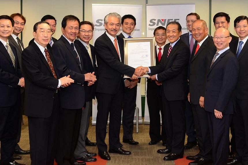 Mr Stephen Lee (centre, right) handing over the Certificate of Registration of SNEF to Dr Robert Yap (centre, left) at the SNEF Council Meeting on July 30, 2014. From left to right: Dr Lim Suet Wun, Mr Douglas Foo, Mr Freddy Lam (front), Mr Robert Ya