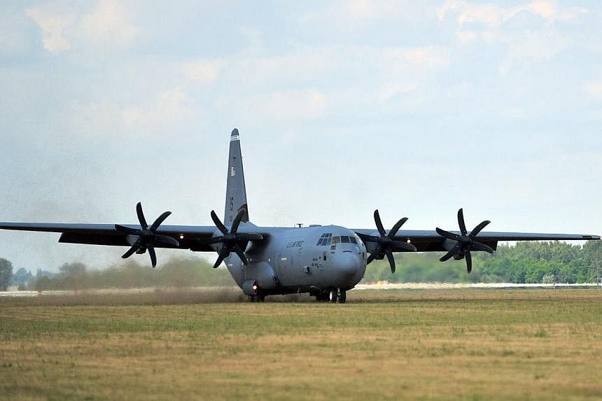 This July 11, 2014 Air Force handout photo shows a US Air Force C-130J Super Hercules from Ramstein Air Base, Germany, performing a grass landing during a training deployment at Powidz Air Base, in Poland. -- PHOTO: AFP