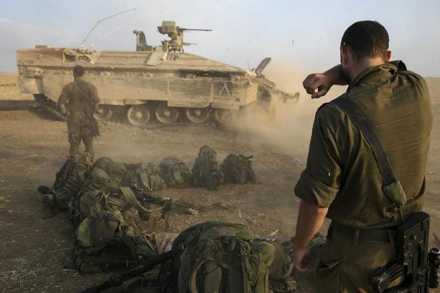 An Israeli soldier stands at a staging area after crossing back into Israel from Gaza. -- PHOTO: REUTERS