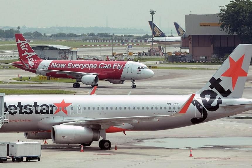 Aircraft of Australian low-cost carrier Jetstar Airways and Malaysian low-cost carrier AirAsia are seen at Changi International Airport in Singapore on May 8, 2014.&nbsp;Australian budget airline Jetstar apologised on Wednesday after a crew member to