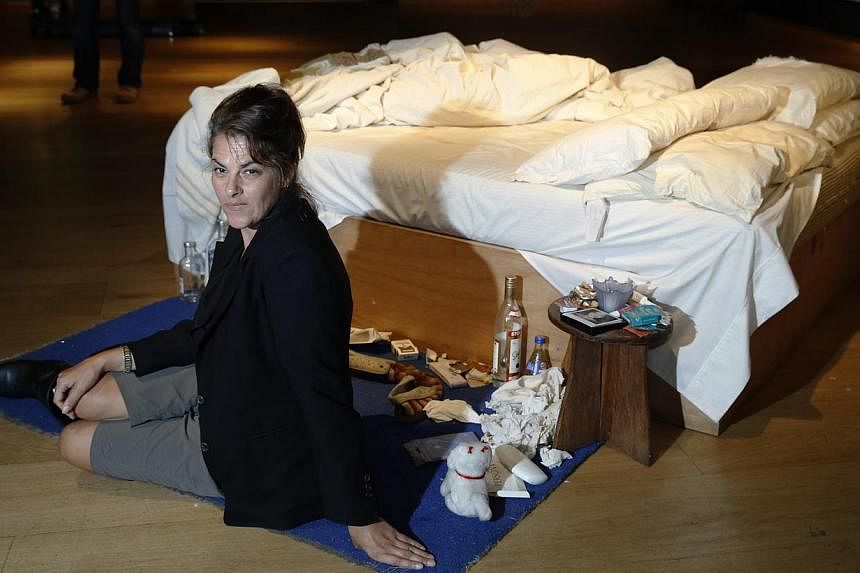 Artist Tracey Emin poses with her conceptual artwork "My Bed" at Christie's auction house in London on June 27, 2014. -- PHOTO: REUTERS