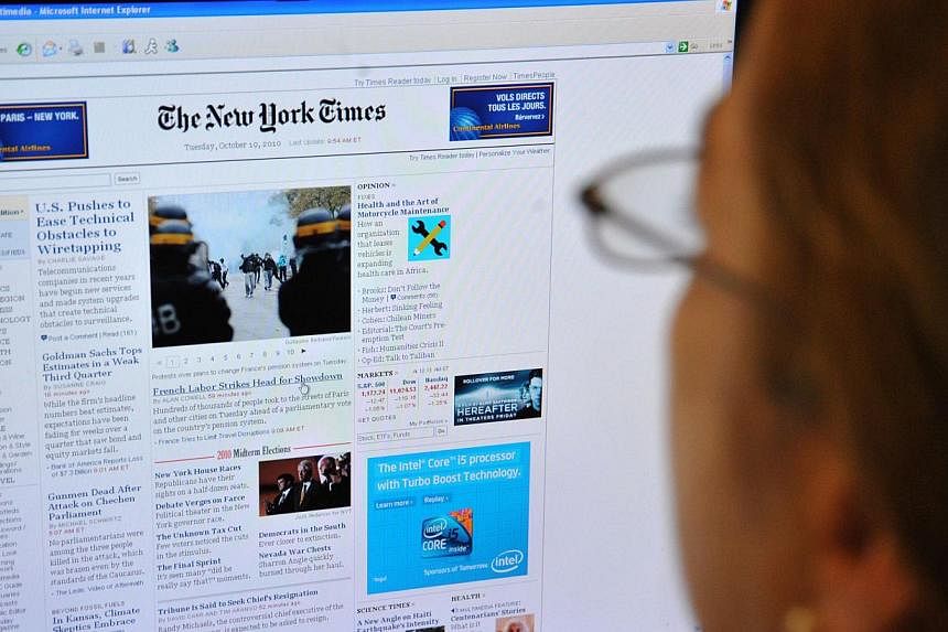 A woman reads the front page of the New York Times on the Internet on Oct 19, 2010 in Washington, DC. The New York Times Co on Tuesday, July 29, 2014, reported a sharp drop in profits as lower advertising revenues offset gains in digital subscription